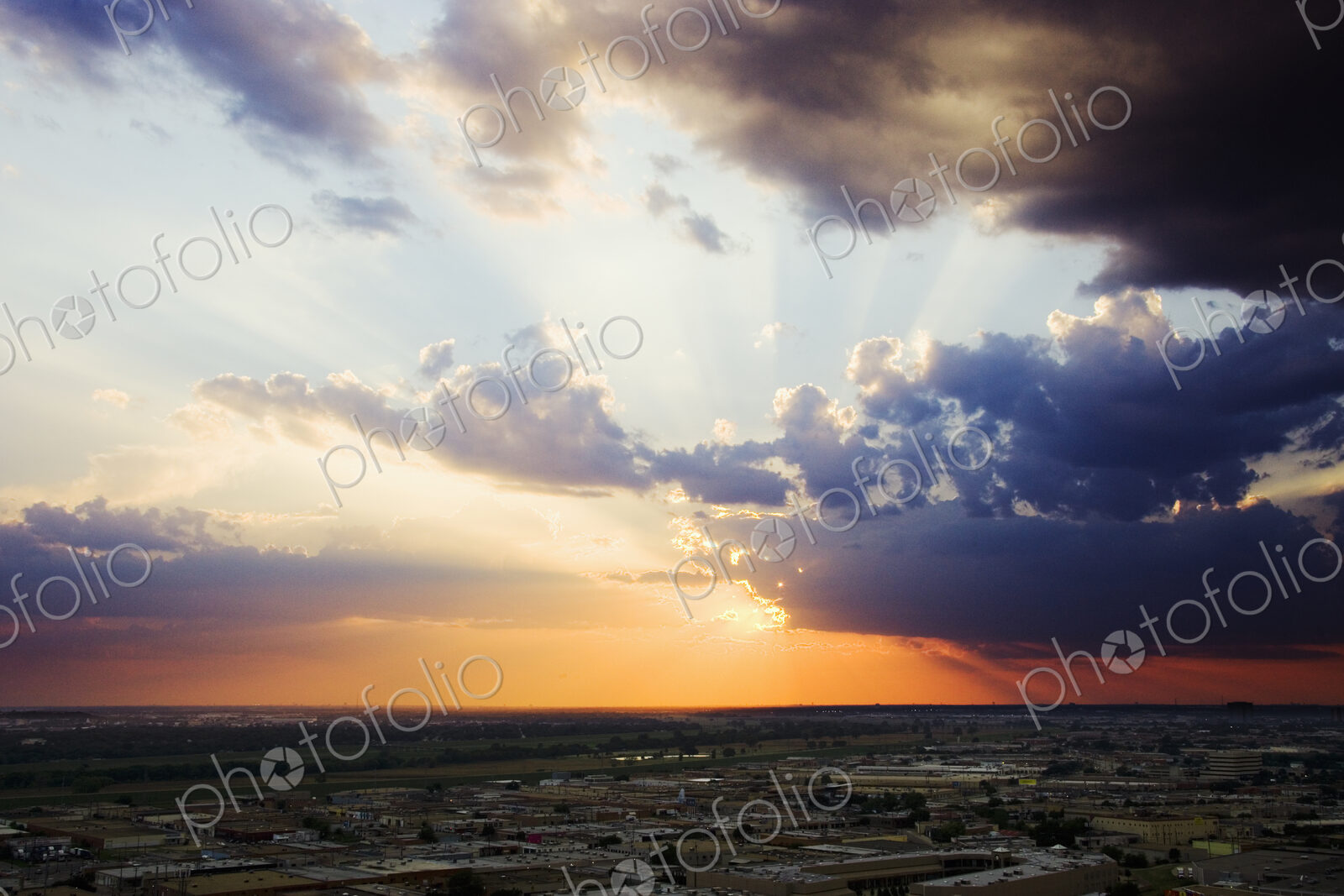 Sunset on the horizon, view over the roofs of light industrial buildings.