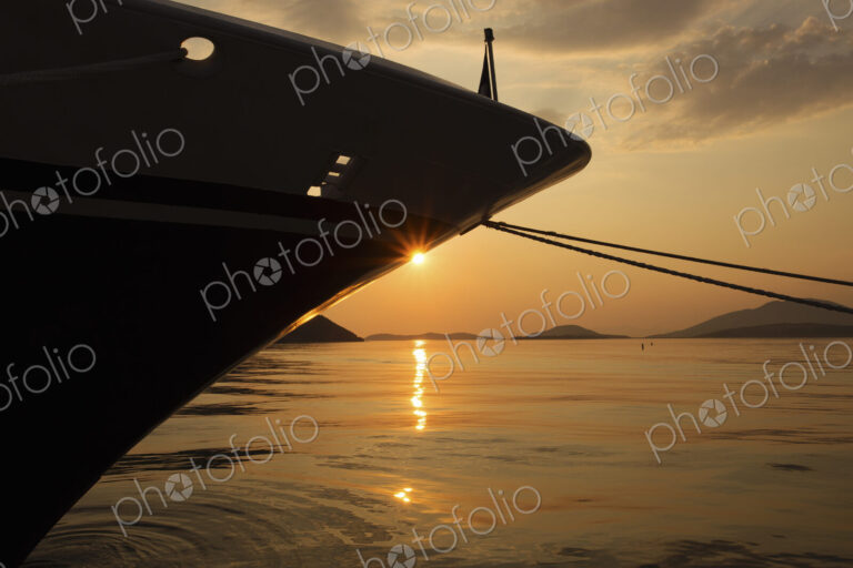 Sunset over the Mediterranean Sea and the view of a ship's bow.