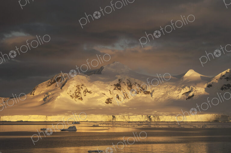 Sunset over the mountainous landscape of Antarctica.