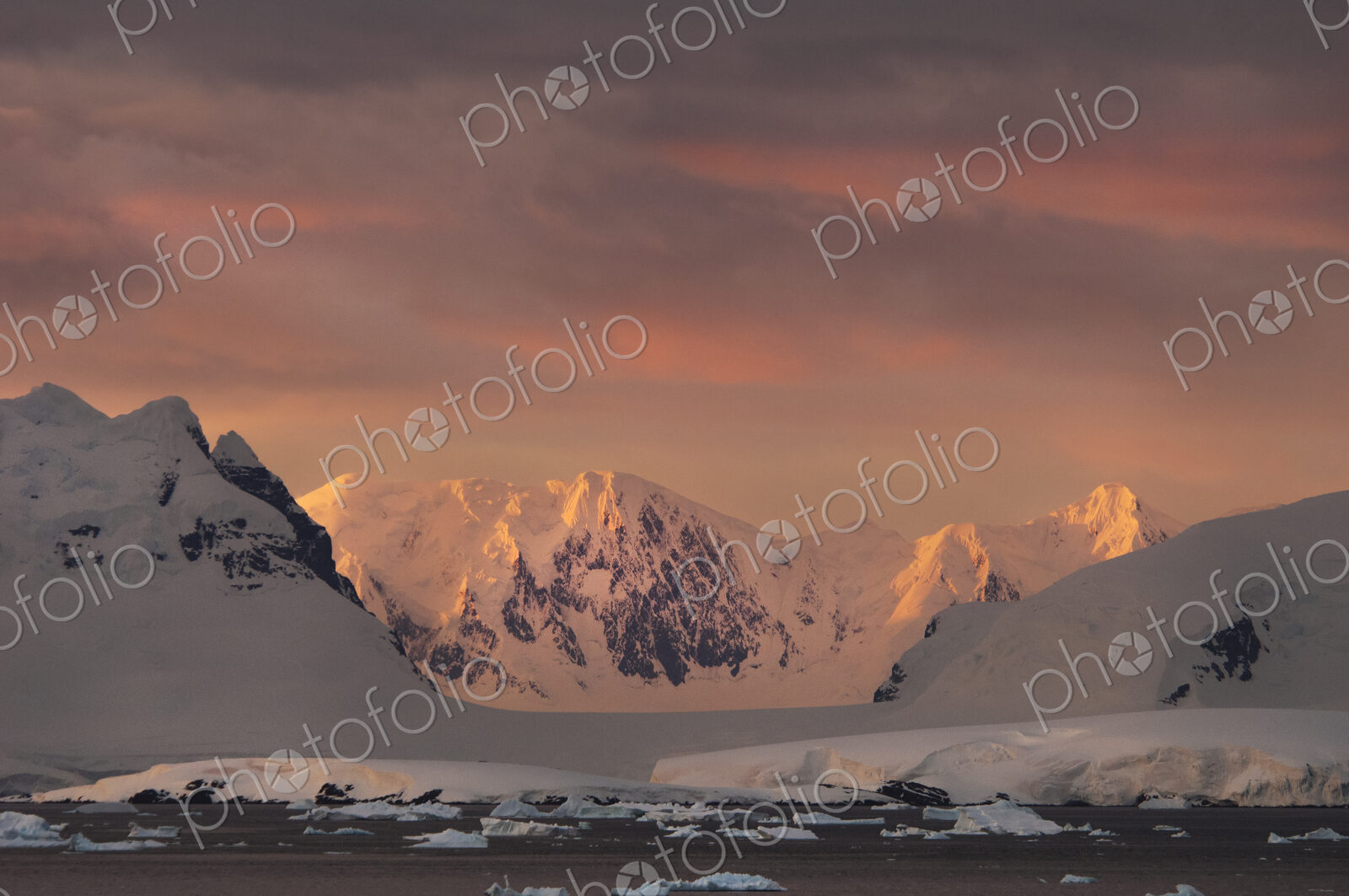 Sunset over the mountainous landscape of Antarctica.
