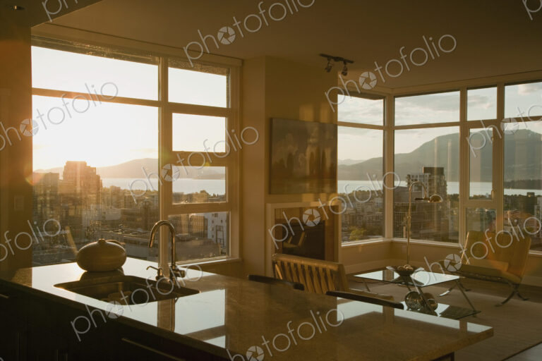 Sunset through windows of open plan apartment.