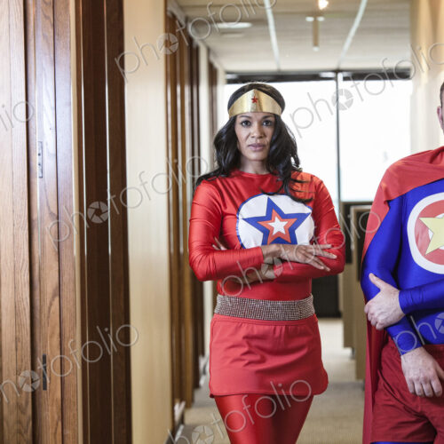 Super hero office team made up of a black woman and a middle aged caucasian man. Super hero office team made up of a black woman and a middle aged caucasian man.