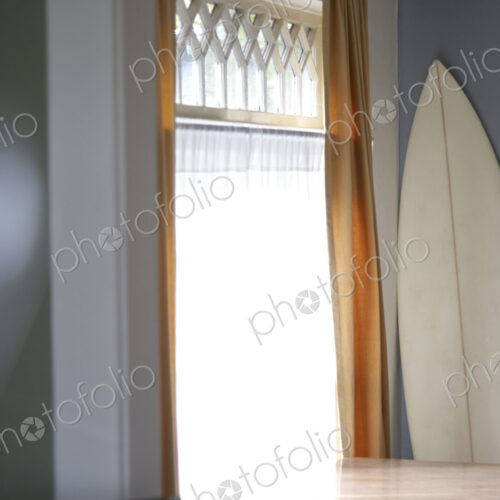 Surfboard and table at window