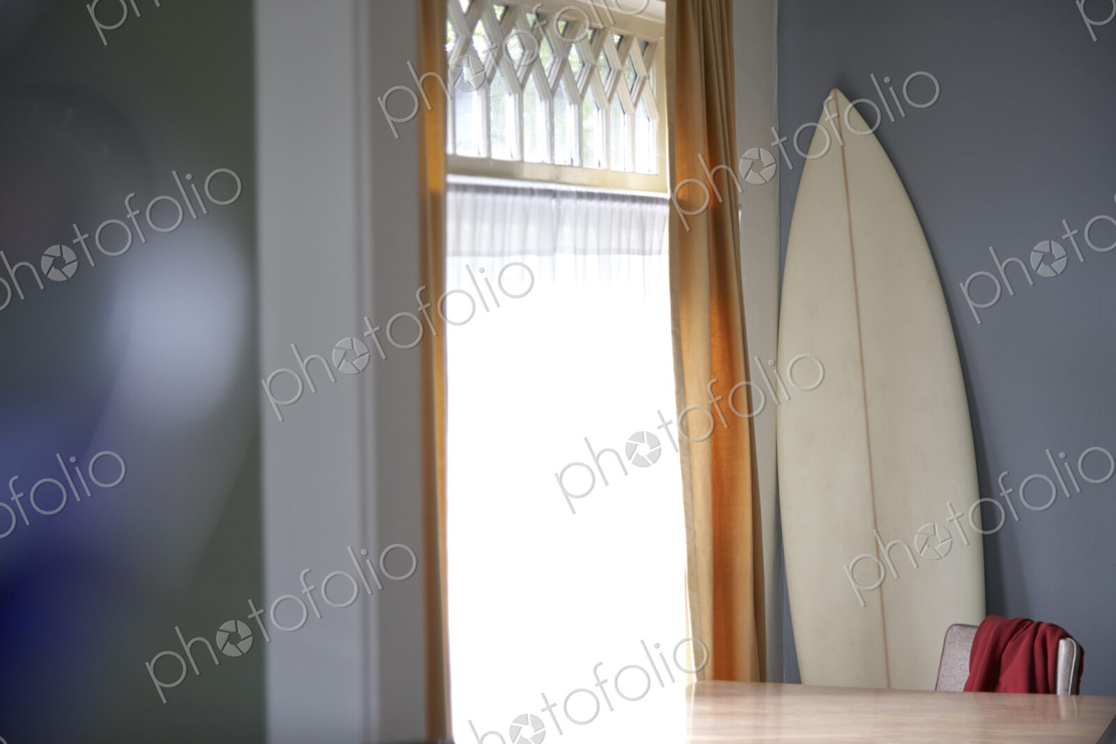 Surfboard and table at window