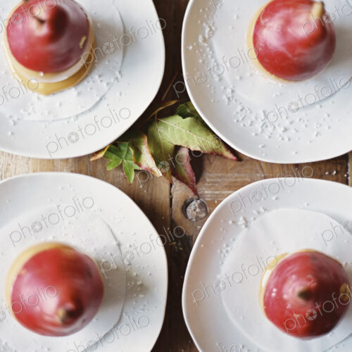 Tabletop viewed from above. Four plates with dessert. Pears dipped in sauce. Tabletop viewed from above. Four plates with dessert. Pears dipped in sauce.