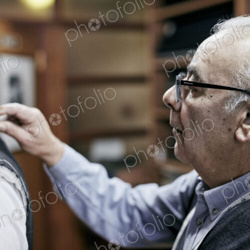 Tailor fitting a jacket on a customer using tailor's chalk to mark the fabric. Tailor fitting a jacket on a customer using tailor's chalk to mark the fabric.