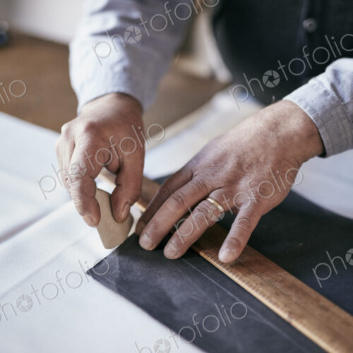 Tailor using chalk and ruler to outline pattern on fabric Tailor using chalk and ruler to outline pattern on fabric