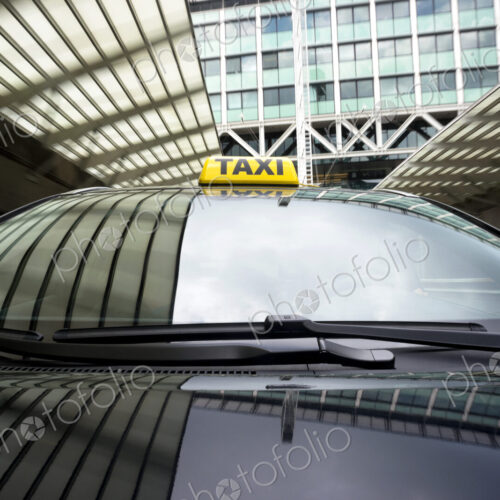 Taxi cab emerging from a garage underneath an office building. Taxi cab emerging from a garage underneath an office building.