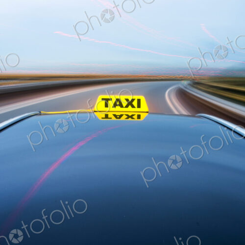 Taxi cab moving along a road, approaching a curve on a motorway exit ramp.