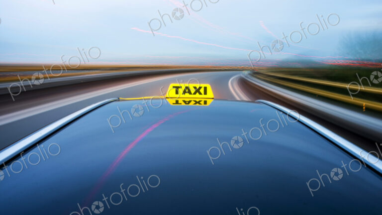 Taxi cab moving along a road, approaching a curve on a motorway exit ramp.