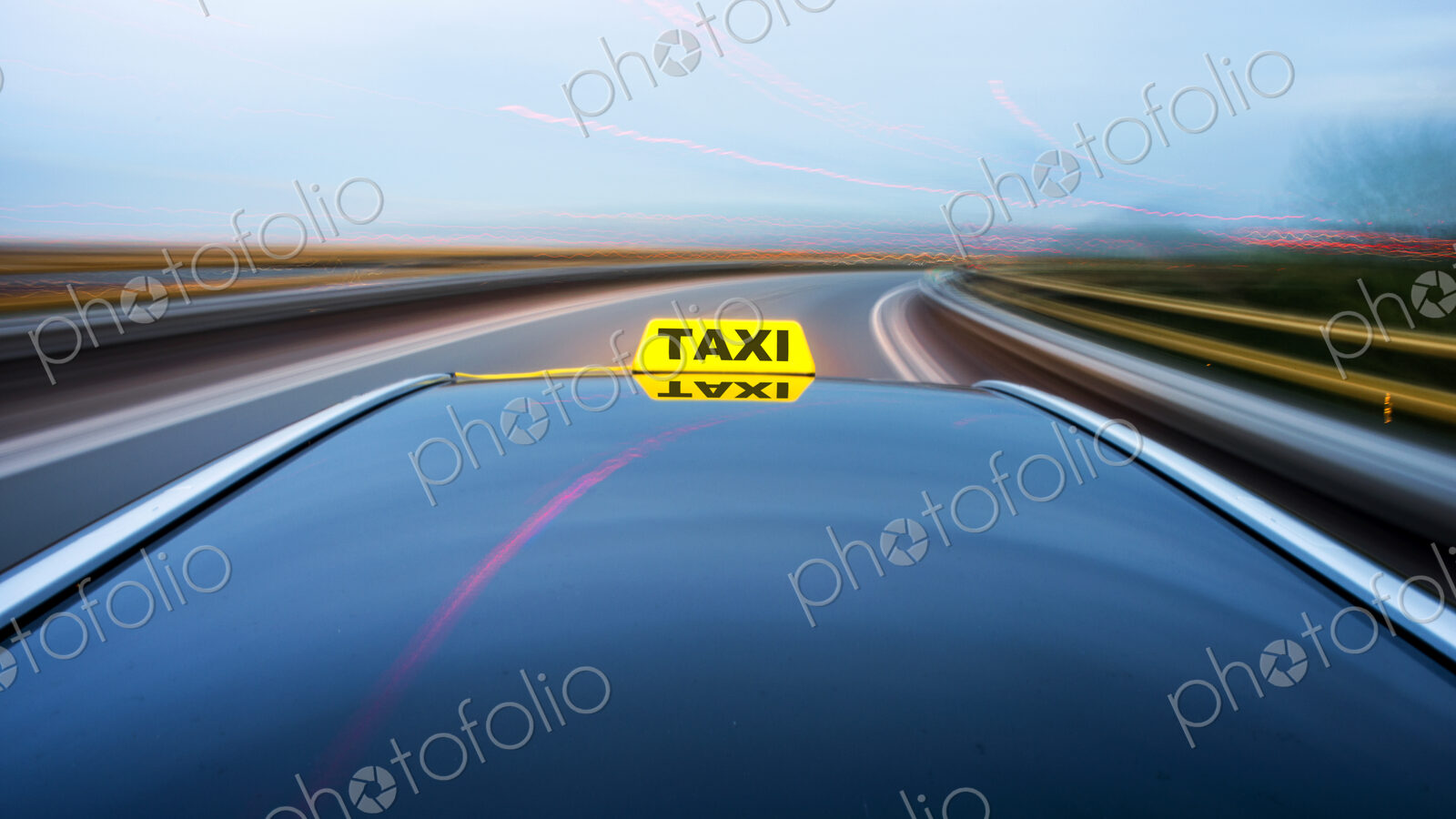 Taxi cab moving along a road, approaching a curve on a motorway exit ramp.