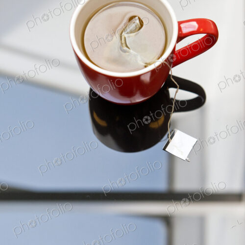 Tea steeping in mug on glass table Tea steeping in mug on glass table