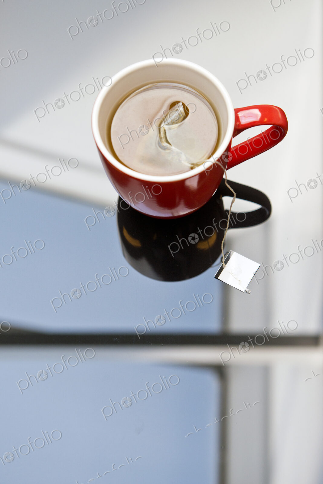 Tea steeping in mug on glass table