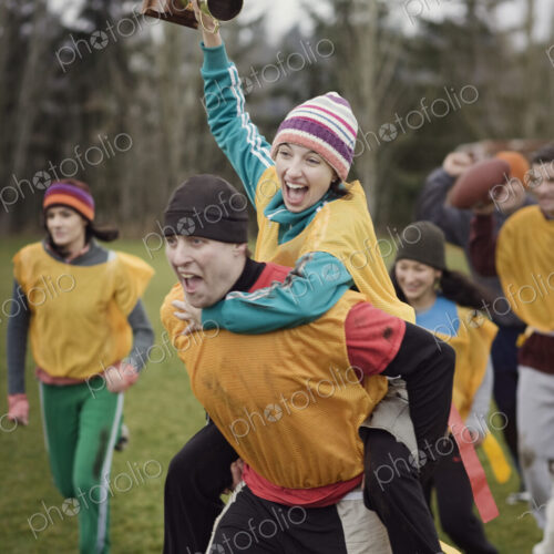 Team members celebrating a victory and a trophy in an outdoor sporting event in the…