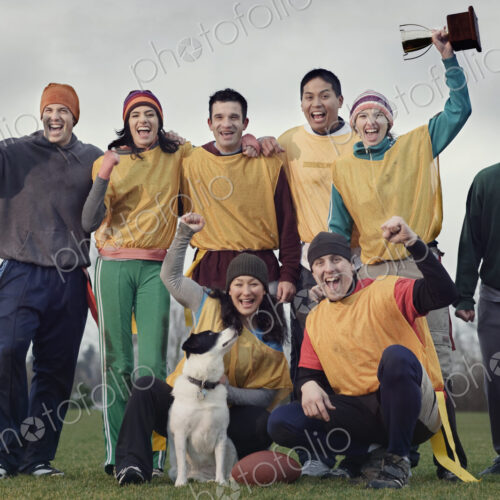 Team members celebrating a victory and a trophy in an outdoor sporting event in the… Team members celebrating a victory and a trophy in an outdoor sporting event in the…