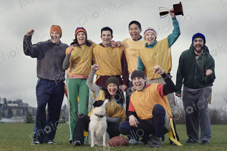 Team members celebrating a victory and a trophy in an outdoor sporting event in the…