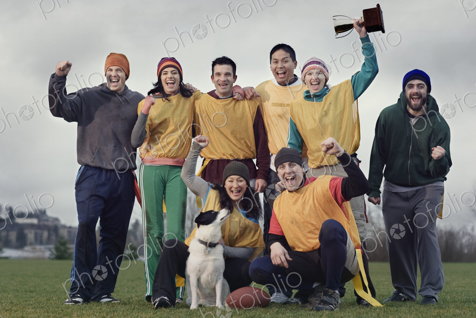 Team members celebrating a victory and a trophy in an outdoor sporting event in the…