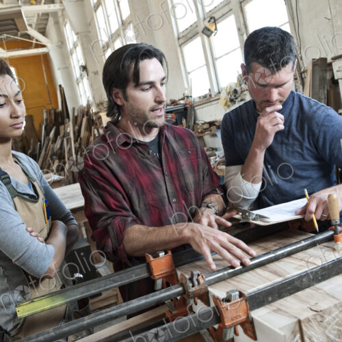 Team of multi-racial workers discussing an issue related to glueing a part together in…
