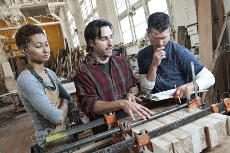 Team of multi-racial workers discussing an issue related to glueing a part together in…