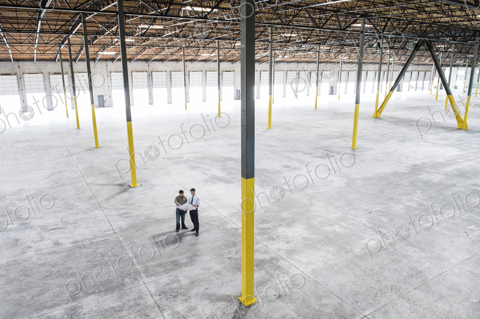 Team of people checking out the new interior of an empty warehouse space.