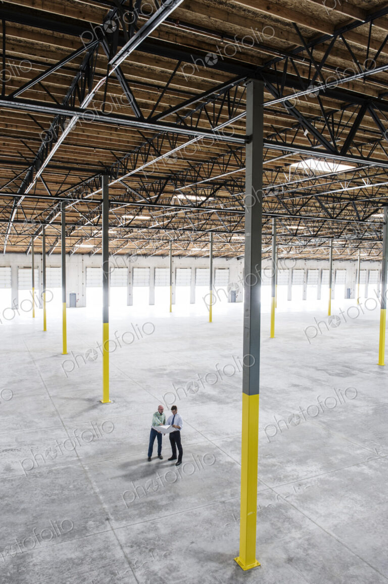 Team of people checking out the new interior of an empty warehouse space.