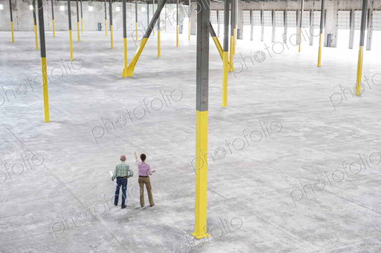 Team of people checking out the new interior of an empty warehouse space.