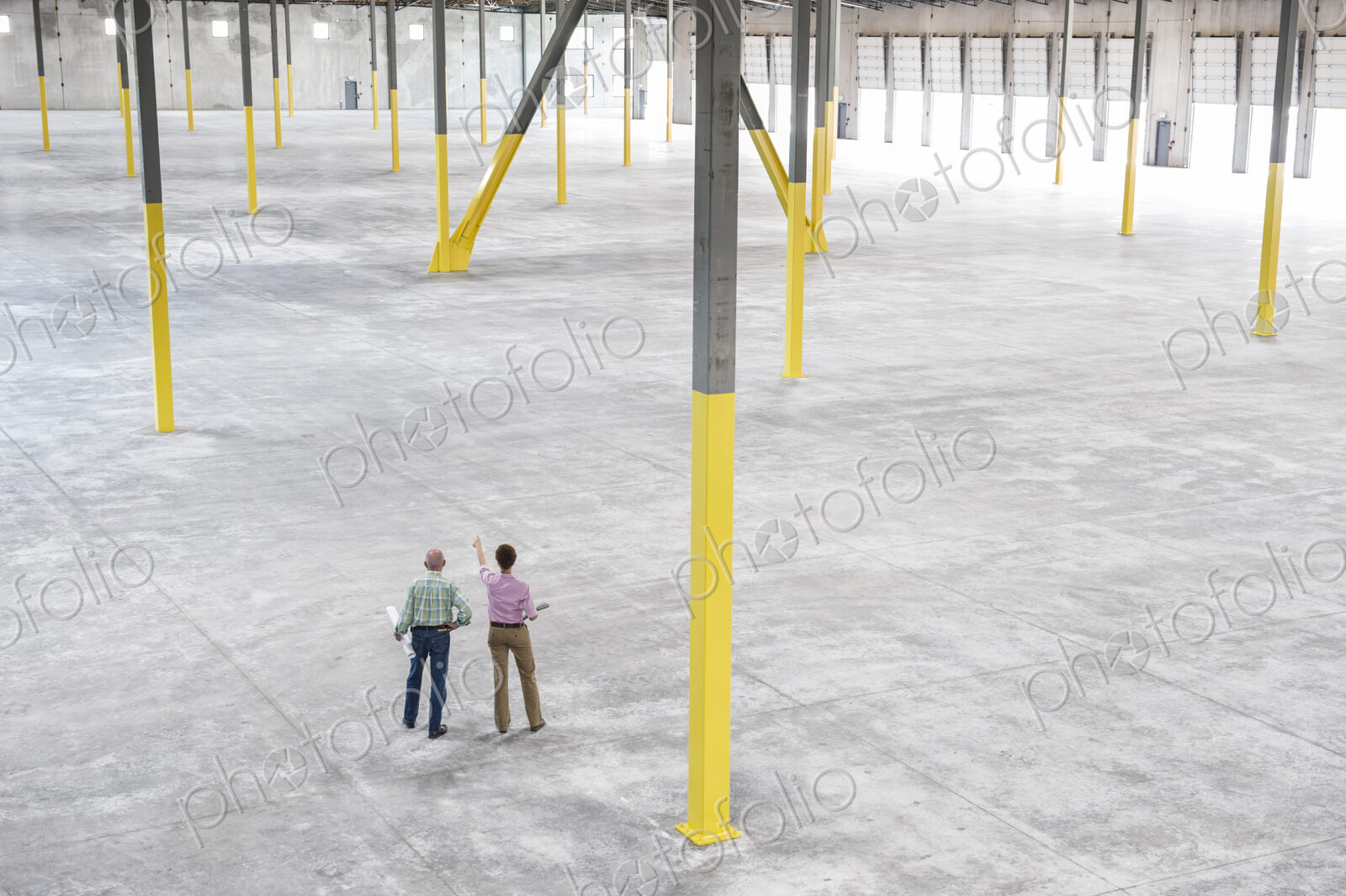 Team of people checking out the new interior of an empty warehouse space.