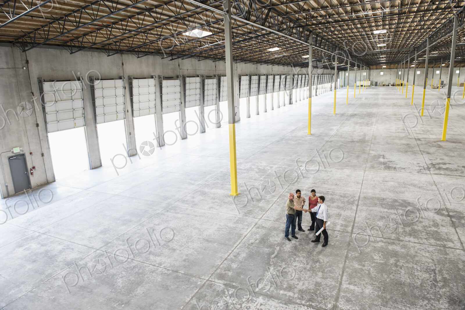 Team of people checking out the new interior of an empty warehouse space.