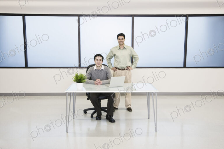 Team of two caucasian businessmen in a computer server farm office.