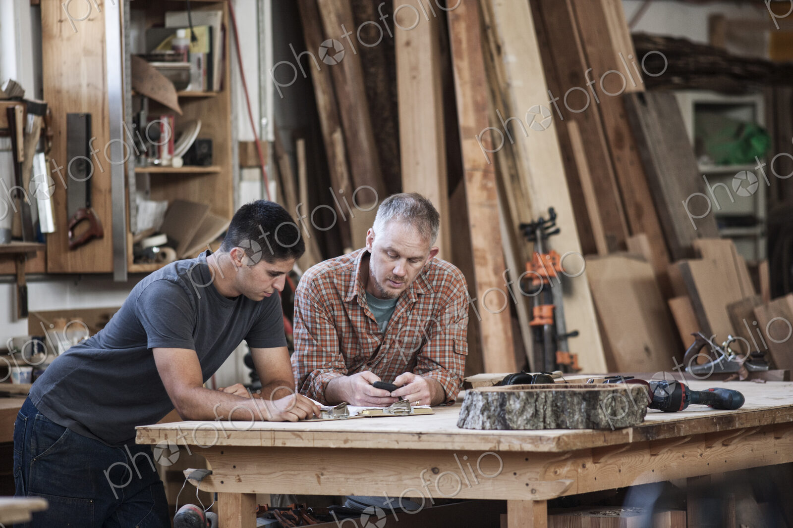 Team of two caucasian men factory workers problem solving at a work station in a…