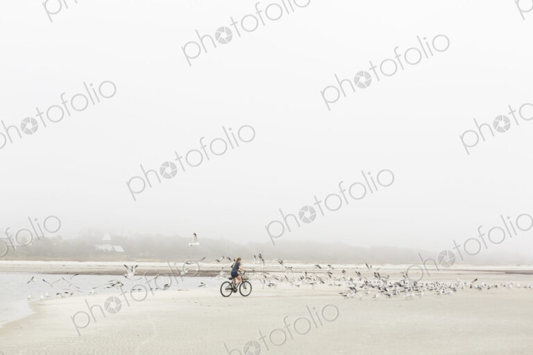 Teen girl biking on sand at the beach, St. Simon's Island Georgia