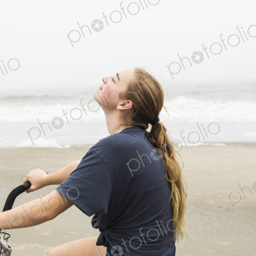 Teen girl biking on sand at the beach, St. Simon's Island Georgia