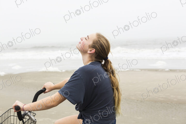 Teen girl biking on sand at the beach, St. Simon's Island Georgia