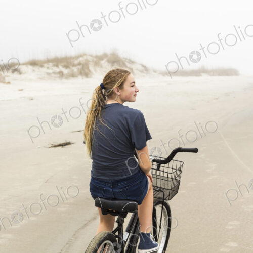 Teen girl biking on sand at the beach, St. Simon's Island Georgia