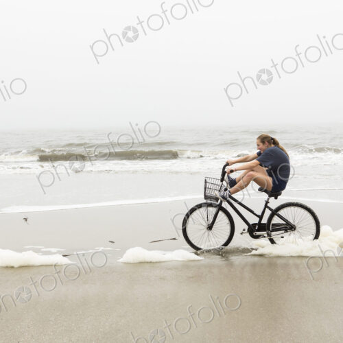 Teen girl biking on sand at the beach, St. Simon's Island Georgia Teen girl biking on sand at the beach, St. Simon's Island Georgia