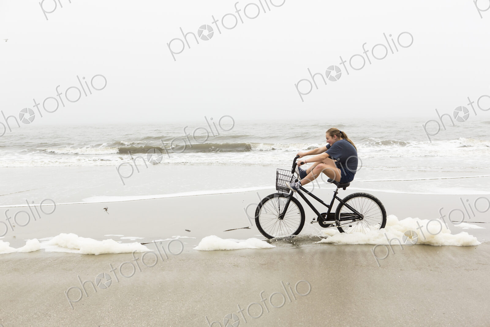 Teen girl biking on sand at the beach, St. Simon’s Island Georgia