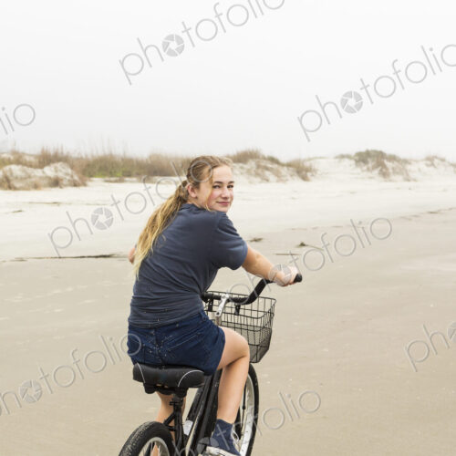 Teen girl biking on sand at the beach, St. Simon's Island Georgia Teen girl biking on sand at the beach, St. Simon's Island Georgia