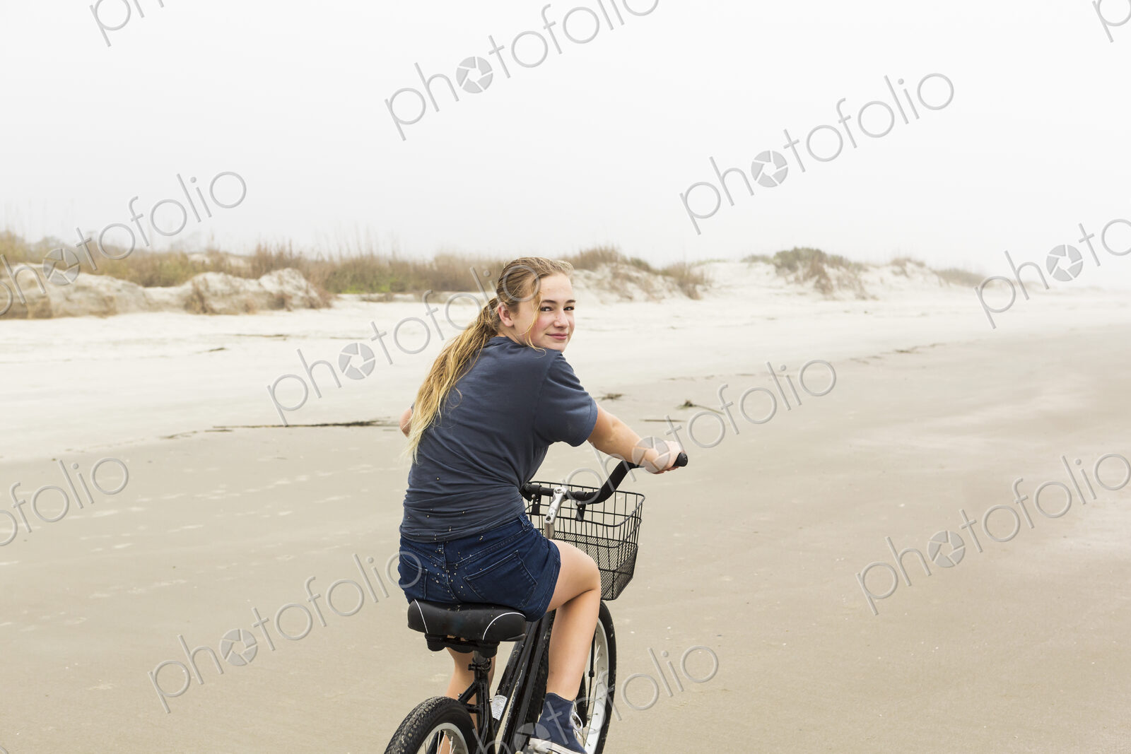 Teen girl biking on sand at the beach, St. Simon’s Island Georgia