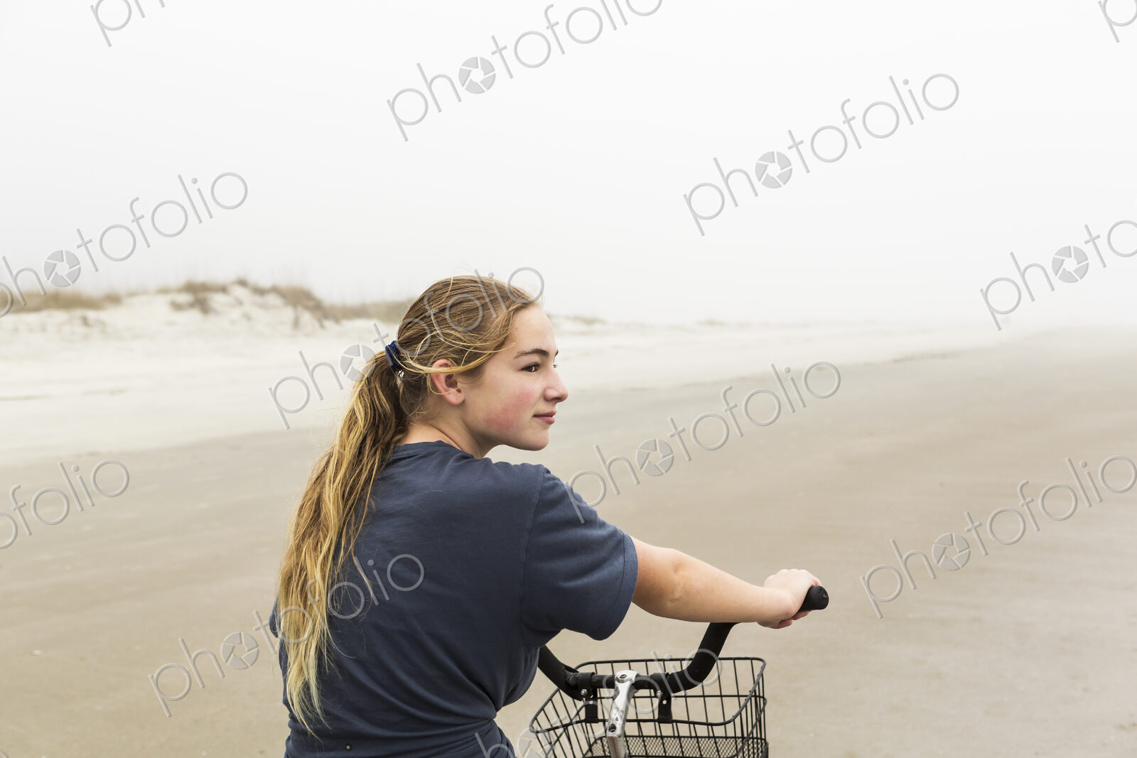 Teen girl biking on sand at the beach, St. Simon’s Island Georgia