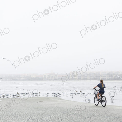 Teen girl biking on sandy beach by the ocean, St. Simon's Island, Georgia Teen girl biking on sandy beach by the ocean, St. Simon's Island, Georgia