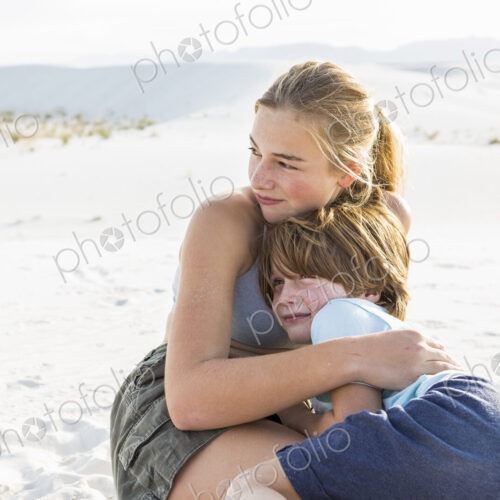 Teen girl embracing her brother, White Sands Nat'l Monument, NM Teen girl embracing her brother, White Sands Nat'l Monument, NM