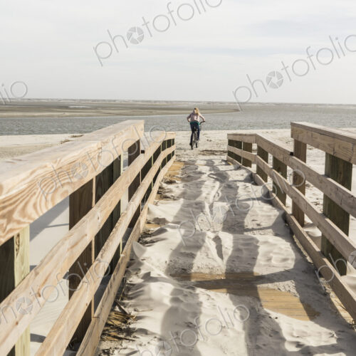 Teen girl on her bike crossing bridge to the beach, St. Simon's Island, Georgia Teen girl on her bike crossing bridge to the beach, St. Simon's Island, Georgia