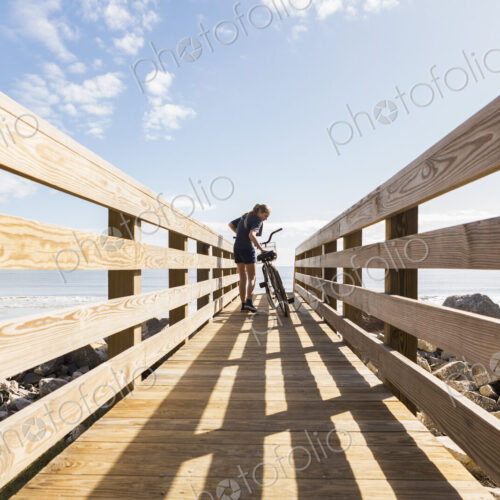 Teenage girl on wooden bridge with her bike Teenage girl on wooden bridge with her bike