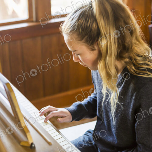 Teenage girl playing piano, practising. Teenage girl playing piano, practising.