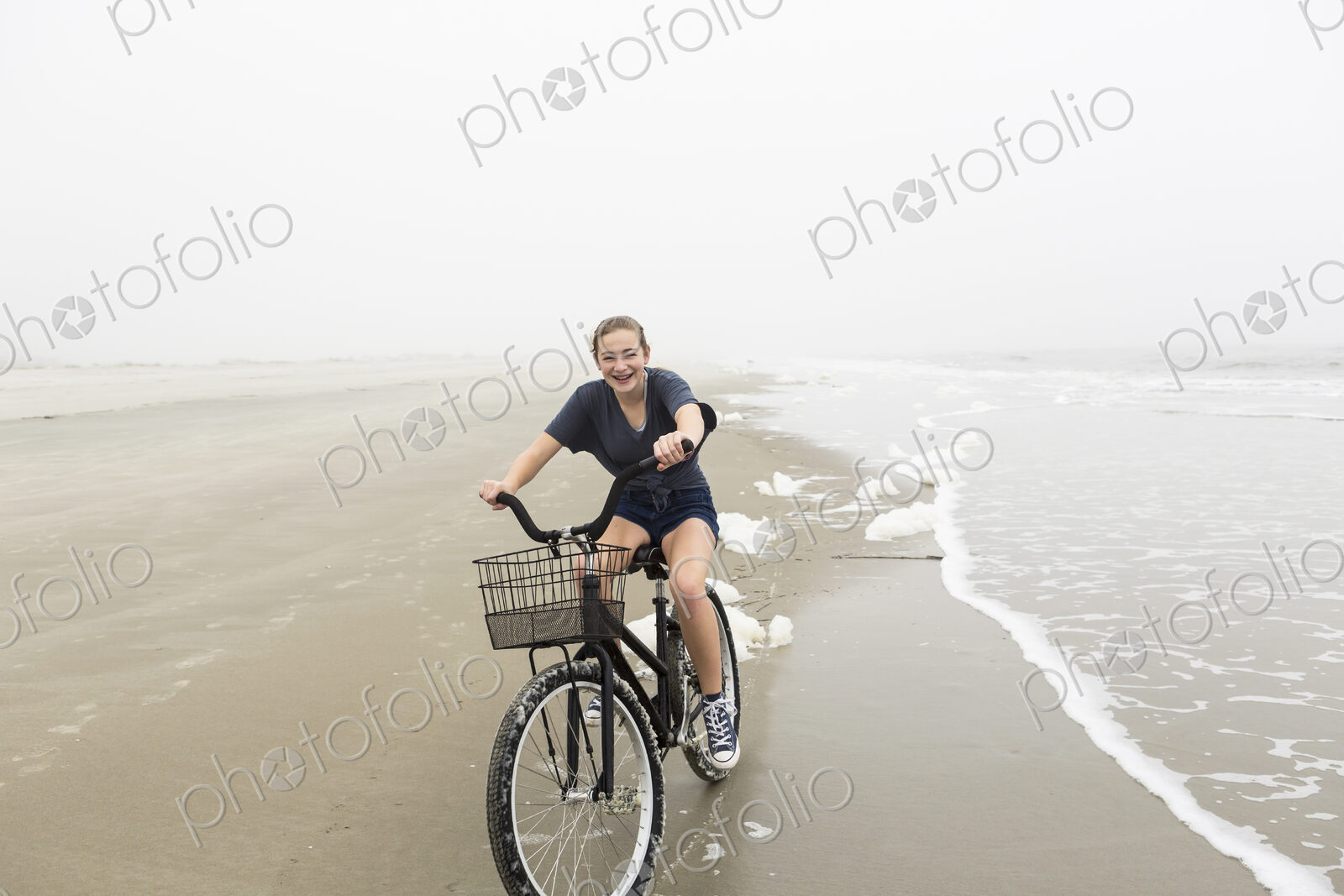 Teenage girl riding a bike on sand at the beach, St. Simon’s Island Georgia