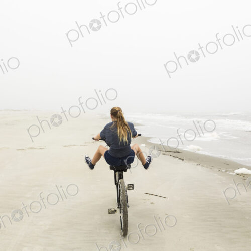Teenage girl riding a bike on sand at the beach, St. Simon's Island Georgia Teenage girl riding a bike on sand at the beach, St. Simon's Island Georgia