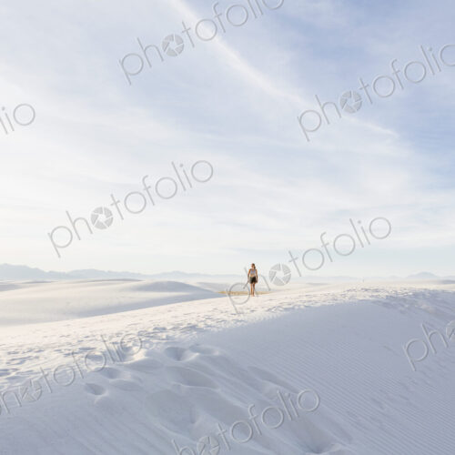 Teenage girl walking in white sand dunes, in open space. Teenage girl walking in white sand dunes, in open space.