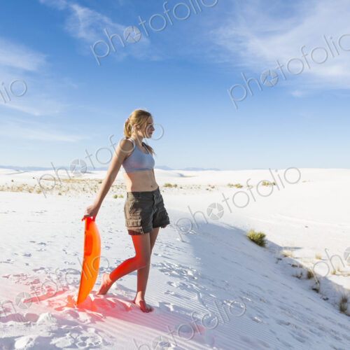 Teenage girl with a sledge at the top of a rise at White Sands Nat'l Monument, NM Teenage girl with a sledge at the top of a rise at White Sands Nat'l Monument, NM