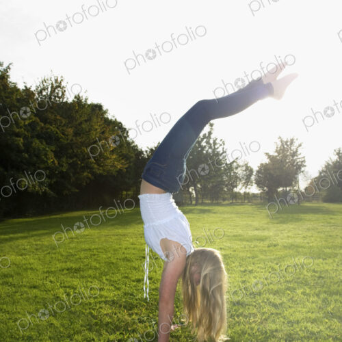 Teenage girl with long blond hair doing a headstand. Teenage girl with long blond hair doing a headstand.