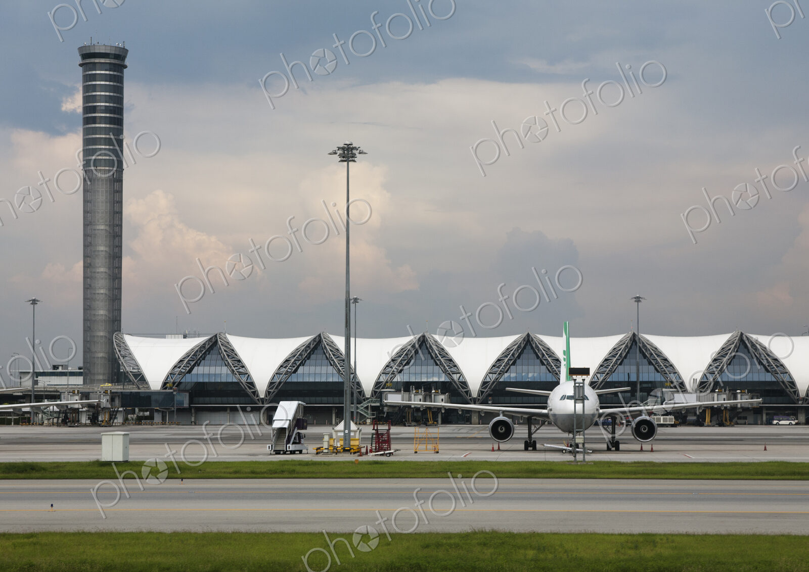 Terminal, control tower and airplane at Bangkok Airport.